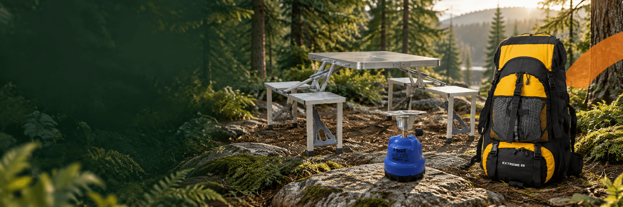 SIBMA outdoor backpack, folding picnic table and camping stove in a forest clearing